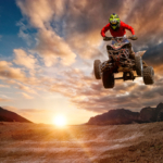 Jazdec na ATV s kompletnými chráničmi počas jazdy v teréne