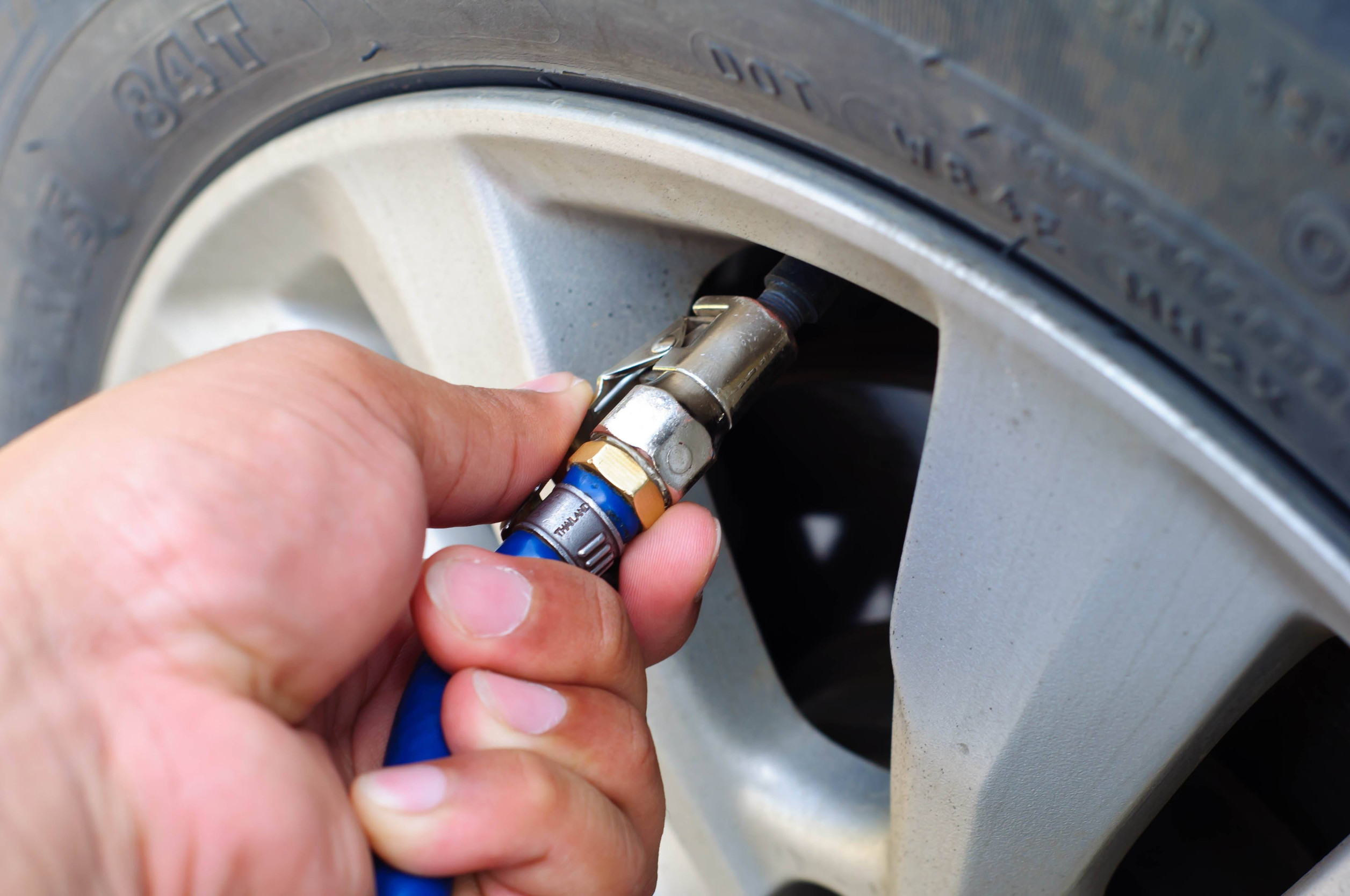 Servisný technik plní pneumatiku automobilu dusíkom.